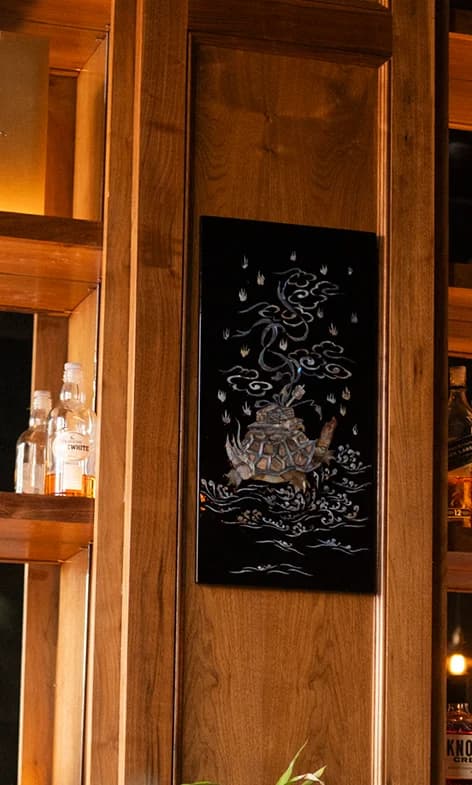 A Vietnamese mother-of-pearl turtle panel hangs on the back bar.